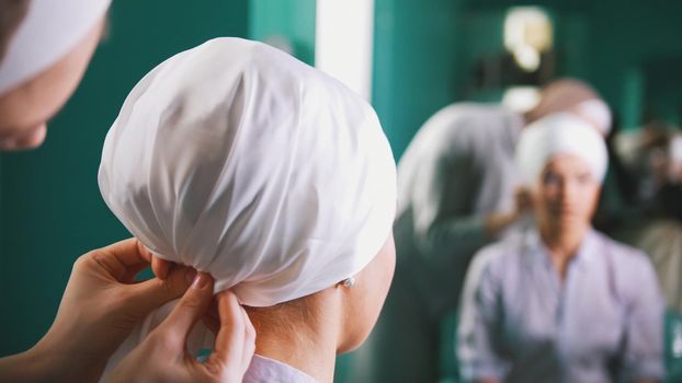Two muslim women to tie Islamic turban, preparing for a wedding near mirror, preparing for a wedding