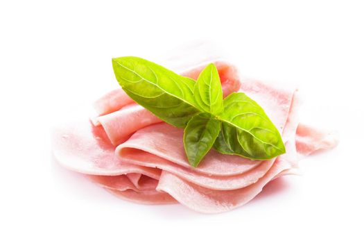 Ham slices isolated on white with green basil leaves