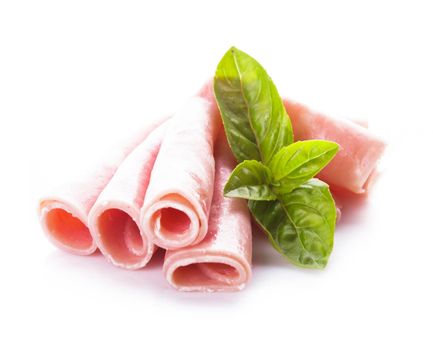 Ham slices isolated on white with green basil leaves