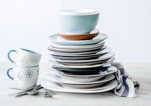 Clean porcelain cups and stack of plates