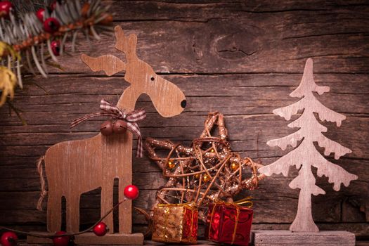 Natural christmas decor - deer and fir tree over wooden background