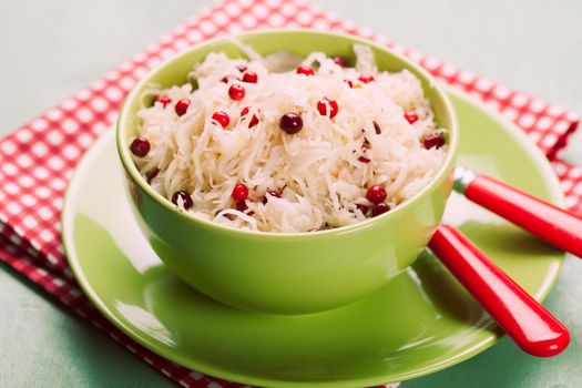 sauerkraut with cranberry in a green bowl