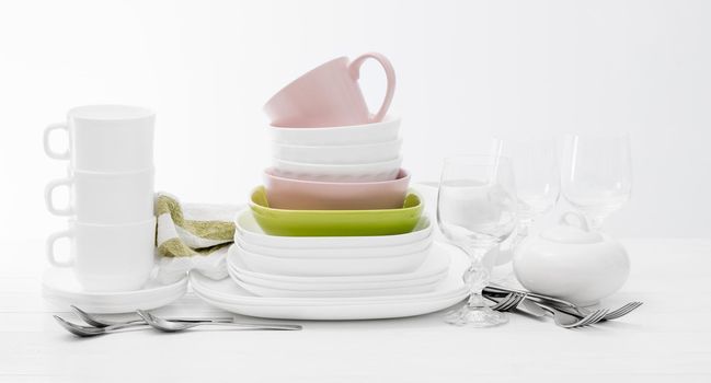 Pile of colourful square dishes and cups with dishcloth