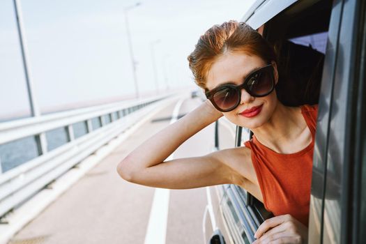woman looking out of car window wearing sunglasses travel lifestyle. High quality photo