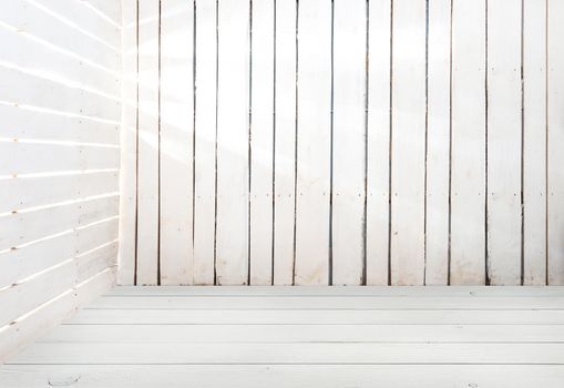 empty white wooden room with light in slits between planks