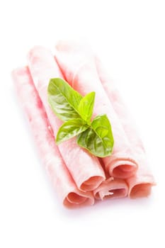 Ham slices isolated on white with green basil leaves