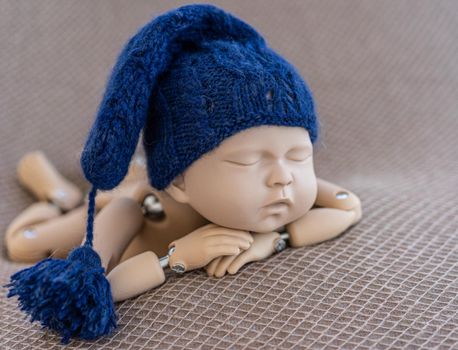 Precisely accurate mannequin of newborn in a hat for photo practicing