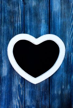 Heart shape chalkboard on the blue wooden wall