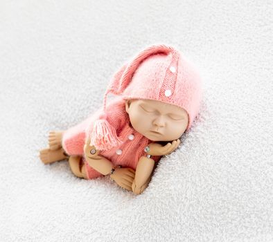 Precisely accurate mannequin of newborn in a hat for photo practicing