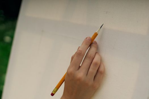 female hand with pencil easel drawing close up. High quality photo