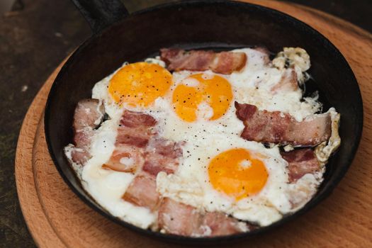 Fried bacon and eggs on the pan - rusty breakfast