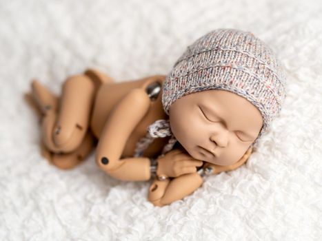 Precisely accurate mannequin of newborn in a hat for photo practicing