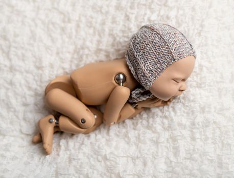 Precisely accurate mannequin of newborn in a hat for photo practicing