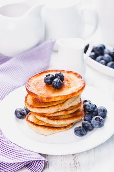 Pancakes with blueberry on a white plate and napkin