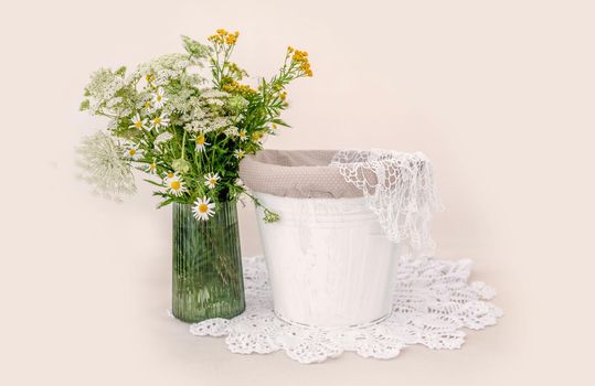 Decoration for newborn studio photoshoot. Cute bucket with knitted textile and flowers bouquet for infant photos