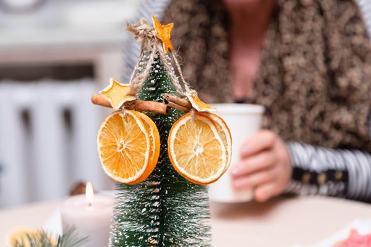 Dried orange, stars from tangerine and cinnamon decoration hanging on a christmas tree. blurred background.
