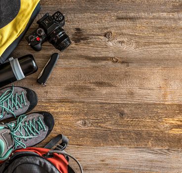Top view of trekking equipment in corner on wooden background with copy space