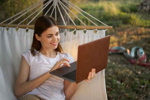 woman with laptop and lies in a hammock vacation nature freelance. High quality photo