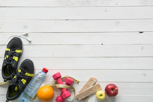 fitness items on wooden planks background top view with text space