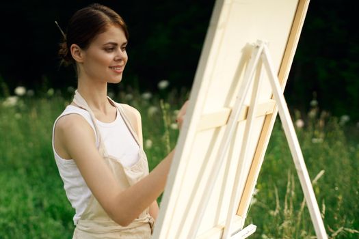 woman artist paints a picture on nature art hobby. High quality photo
