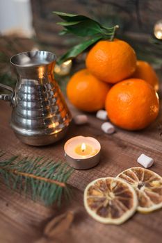 New year's still life with fresh mandarines, lighted candle and cofee turka on wooden background. Nature Christmas concept in instagram style