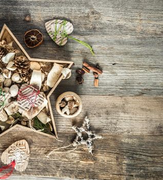 christmas decorations in star shaped box on old wooden background with text space top view