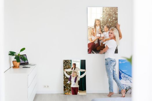 woman holding photo canvas on the background of a interior.