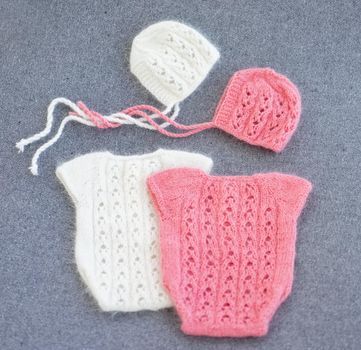 knitted newborn baby clothes composed on the woolen background