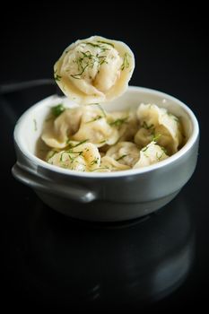 boiled dumplings with meat filling in a bowl on the table