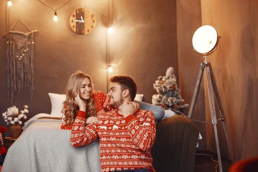 People in a Christman decorations. Man and woman in a red sweater. Family at home.