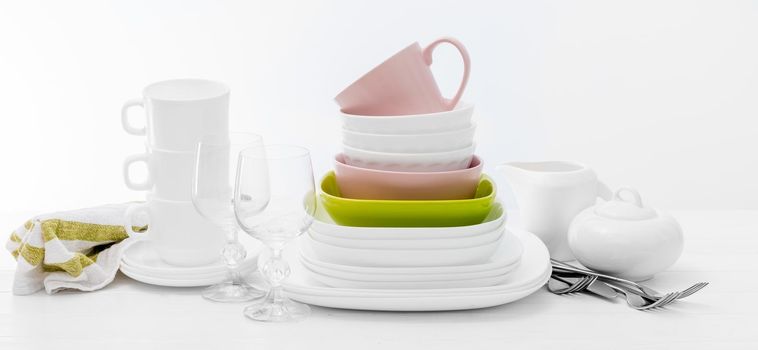 Pile of colourful square dishes and cups with dishcloth