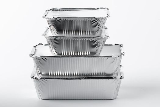 Takeaway meal in foil food box on white background close up