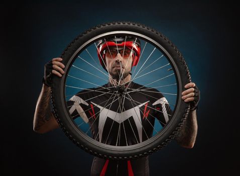 guy-cyclist in a Bicycle helmet with a Bicycle wheel