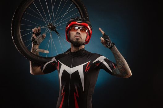 a guy-cyclist in a Bicycle helmet with a Bicycle wheel