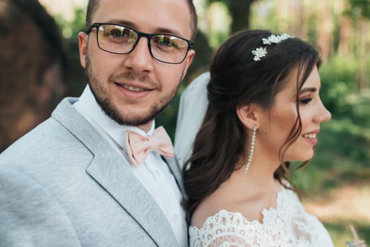 Wedding photo of the bride and groom in a gray-pink color on nature in the forest and rocks