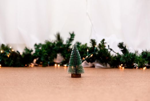 Miniature christmas tree on the blurred background with christmas lights. Image for Christmas Holiday decorative concept. Minimal concept.