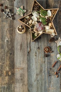 christmas decorations in star shaped box on old wooden background with text space top view