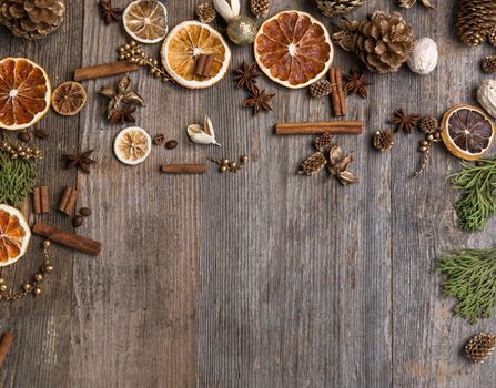 Christmas decorations on an old wooden background with cinnamon and dried orange slices. Space for text