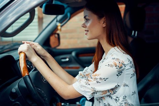 cheerful woman driving a car looks out of the window. High quality photo