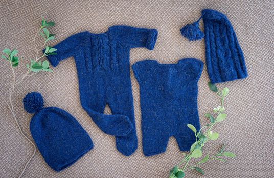 knitted newborn baby clothes composed on a fabric