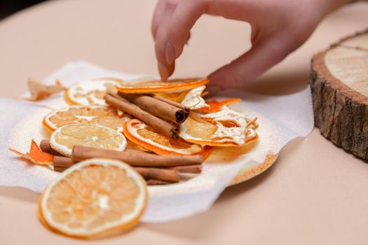 Women's hand making decorations from dried oranges, stars from tangerine and cinnamon. Girls party or meeting.