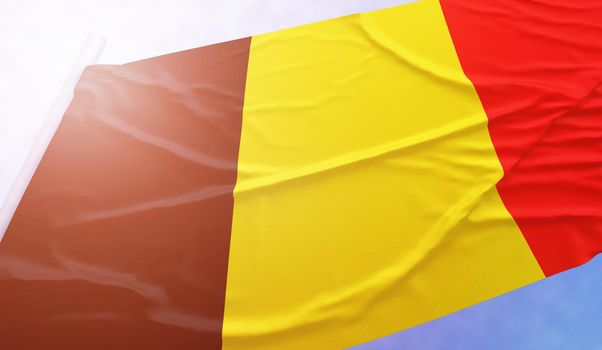 Belgium flag on the blue sky. Close up national flag in bright rays sun that is waving in the wind on flagpole.