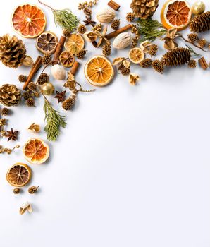 christmas decorations background with space for text of dried oranges, cinnamon and cones. white background