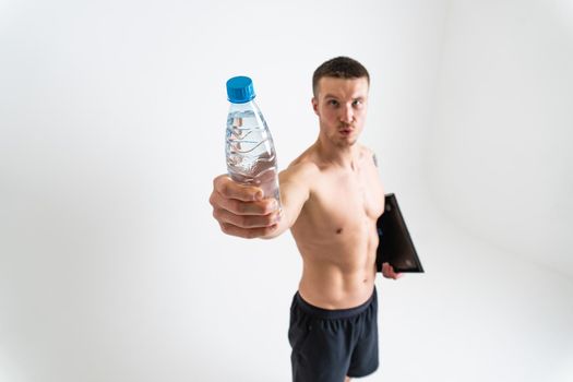 Male drink-water fitness is pumped with a towel on a white background isolated fit workout health, water energy nutrition guy, background Strength protein active, tired one muscle