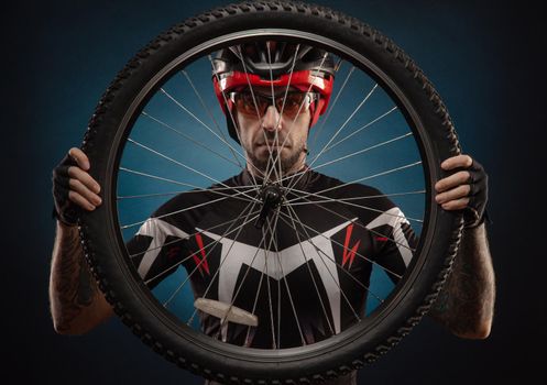 a guy-cyclist in a Bicycle helmet with a Bicycle wheel