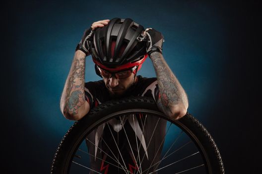 a guy-cyclist in a Bicycle helmet with a Bicycle wheel