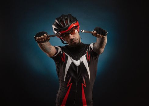 a guy-cyclist in a Bicycle helmet with repair keys