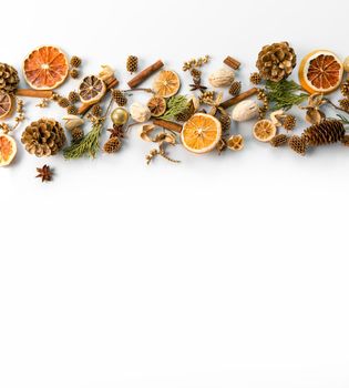 christmas decorations background with space for text of dried oranges, cinnamon and cones. white background