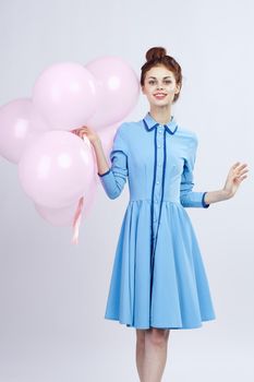 cheerful woman in a blue dress pink balloons holiday birthday. High quality photo