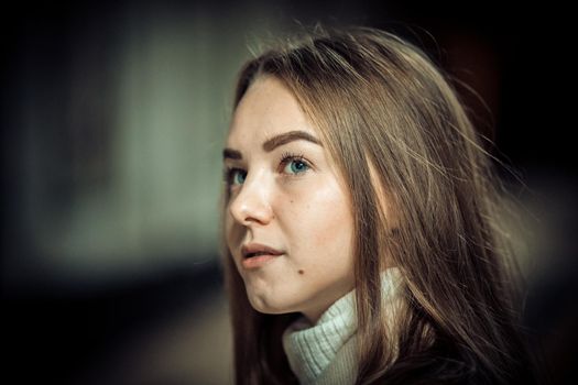 Portrait of young woman in the subway waiting for the train. Looking to the side. Close up